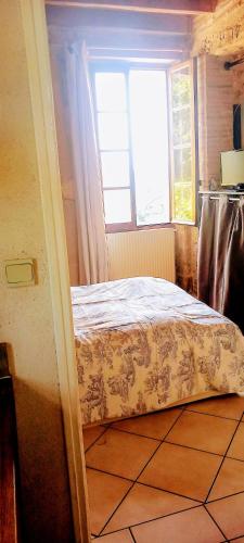 une chambre avec un lit et une fenêtre dans l'établissement La Chataîgnière, à Saint-Géry