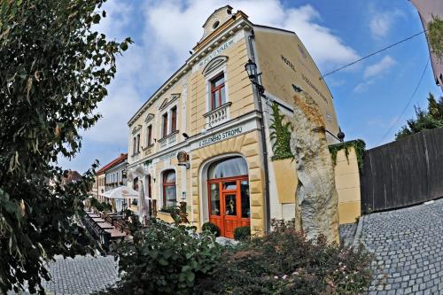 a large yellow building with a red door at Hotel U Zeleneho stromu in Nepomuk