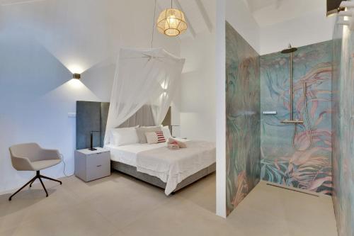a bedroom with a bed and a desk and a chair at Las Dunas with Stunning Sea View and Shared Pool in Kralendijk