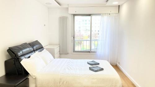 une chambre blanche avec un lit et une fenêtre dans l'établissement 109 - 100m2 Suite Opulence Royale, à Courbevoie