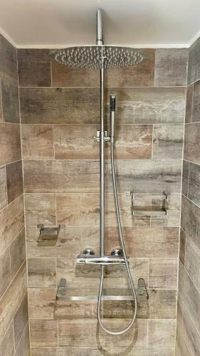 La salle de bains est pourvue d'une douche et de carrelage en bois. dans l'établissement 109 - 100m2 Suite Opulence Royale, à Courbevoie