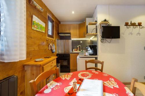 une petite cuisine avec une table et un chiffon rouge dans l'établissement Les Airelles 32, à Villarodin-Bourget