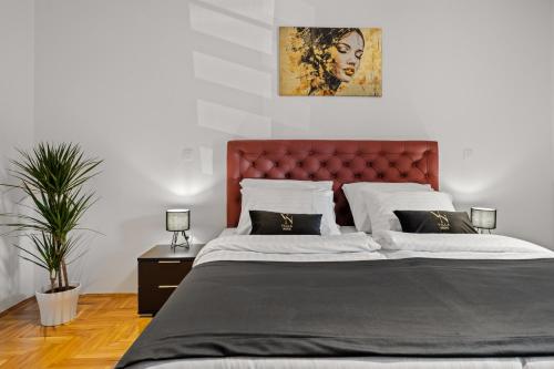 a bedroom with a large bed with a red headboard at Villa Nene in Benažići