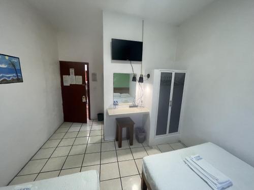 a room with a bed and a sink and a mirror at Hotel Oasis Cuyutlan in Cuyutlán