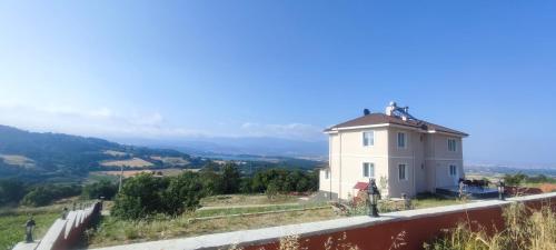 a white house on a hill with a view at Akkayalar Aerie House in Çepni