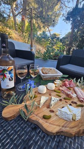 a wooden cutting board with wine glasses and food on a table at Maison Allauch La Gloire de mon Père in Allauch