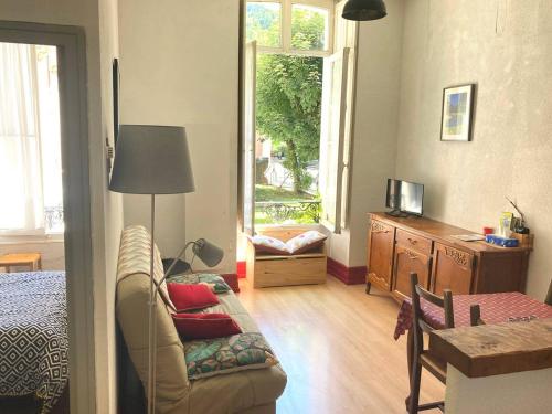 - un salon avec un canapé, un lit et une fenêtre dans l'établissement Charmant T2, 4 pers, Centre Cauterets, Proche Télécabine, Parking Gratuit - FR-1-234-313, à Cauterets