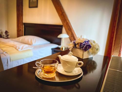 a cup of tea on a table in a bedroom at Hotel U Zeleneho stromu in Nepomuk