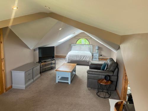 a attic bedroom with a bed and a couch at Cherry Blossom lodge deluxe loft in Marton