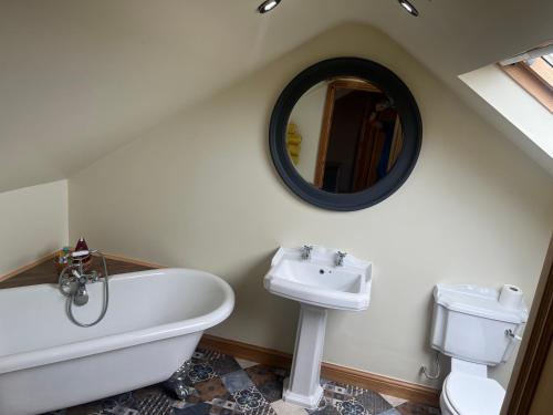 a bathroom with a tub and a sink and a mirror at Cherry Blossom lodge deluxe loft in Marton