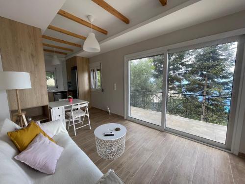 Ionian home في Exanthia: غرفة معيشة مع باب زجاجي منزلق كبير