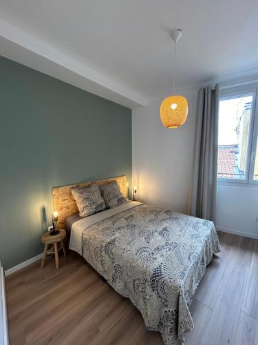 une chambre avec un lit et une grande fenêtre dans l'établissement Le Miquel-Appartement Béziers Centre, à Béziers