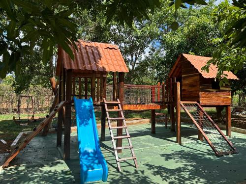 a playground with a slide and a house at Pousada Raio de Luz in Pirenópolis
