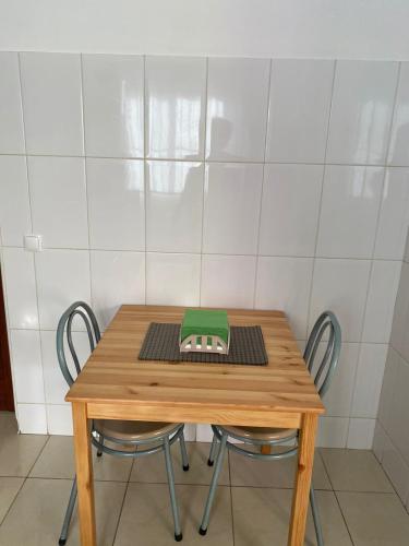 a wooden table with two chairs and a laptop on it at Katila-Rooms-Lima in Espargos