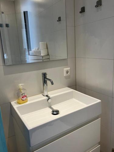 a bathroom with a white sink and a mirror at Appartement Martina 22 in Vlissingen