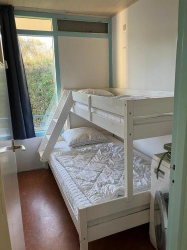 two bunk beds in a room with a window at Appartement Martina 22 in Vlissingen