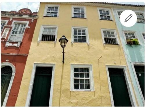 a yellow building with a street light in front of it at São Francisco Aparts in Salvador