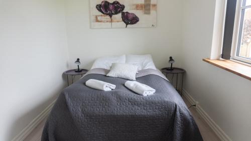 a bedroom with a bed with two towels on it at Hilmor's Lejligheder in Viborg
