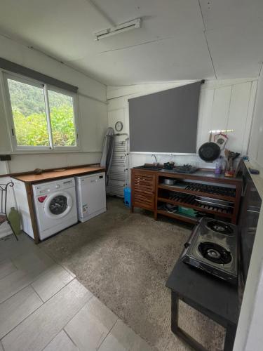 a kitchen with a stove and a washing machine at L'Écrin de Langevin in Saint-Joseph