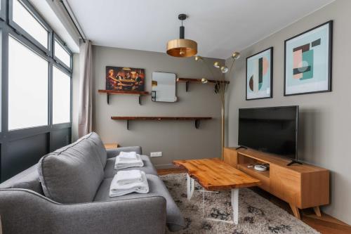 un salon avec un canapé et une télévision dans l'établissement Cosy apartment - 1BR-4P - Near Nation, à Paris