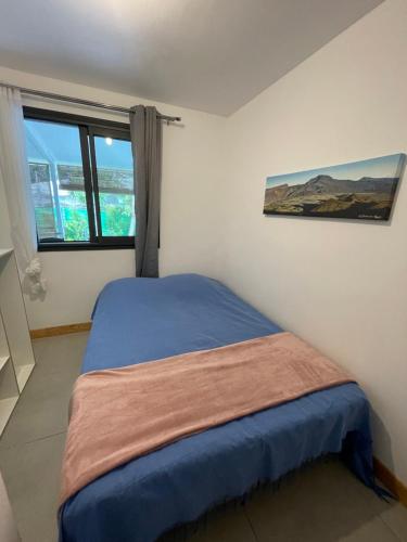 a small bedroom with a bed with a window at L'Écrin de Langevin in Saint-Joseph