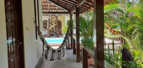 una veranda con amaca e piscina di Pousada Paraíso do Mundo a Morro de São Paulo