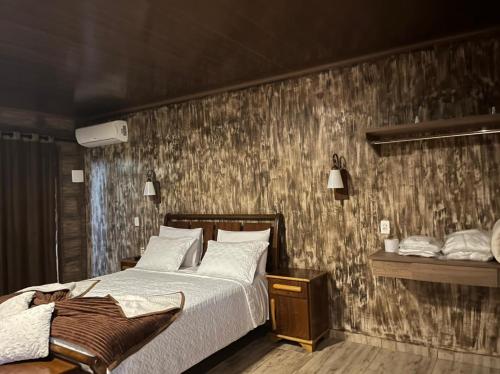 um quarto com uma cama e uma parede de madeira em Pousada Raio de Luz em Pirenópolis