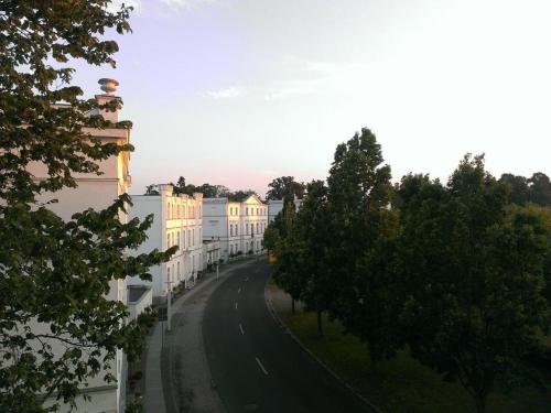 an empty street with trees on the side of a building at Fürstlich wohnen im Obergeschoss in Putbus