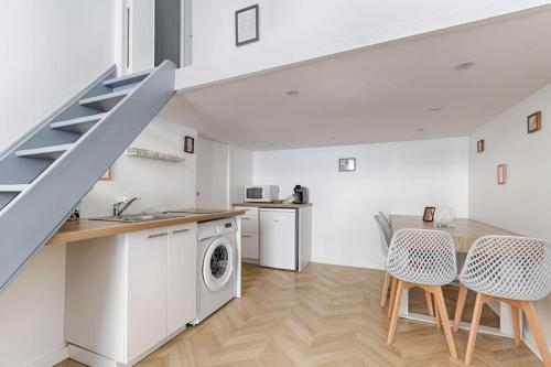 une cuisine et une salle à manger avec un escalier et une machine à laver dans l'établissement Sentier Historical Center III Charming Apartment, à Paris