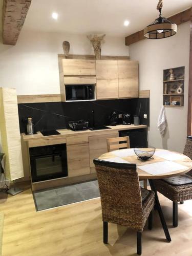 une cuisine avec une table et des chaises dans une pièce dans l'établissement La Pierre De Lave appartement Le Corsaire, à Agde