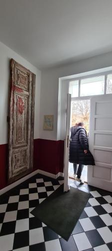 a person standing at the door of a room at Fürstlich wohnen im Obergeschoss in Putbus