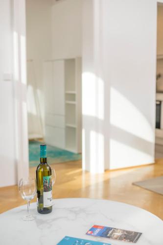 a bottle of wine and a wine glass on a table at Luxury Suites Liechtenstein in Vienna
