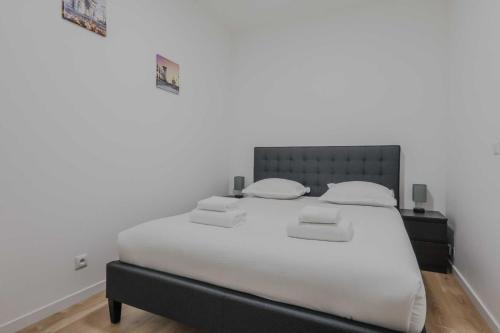 une chambre avec un grand lit avec des draps blancs dans l'établissement Modern Apartment - 2BR-6P- Levallois-Perret, à Levallois-Perret