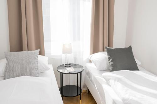 a bedroom with two white beds and a table at Luxury Suites Liechtenstein in Vienna