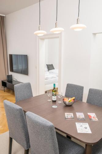a dining room with a table and chairs and a bed at Luxury Suites Liechtenstein in Vienna