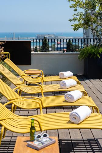 a group of yellow chairs sitting on a patio at Schumacher Hotel Haifa in Haifa