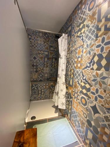 a bathroom with a shower with a window and tiles at The Pink House in Faja Grande
