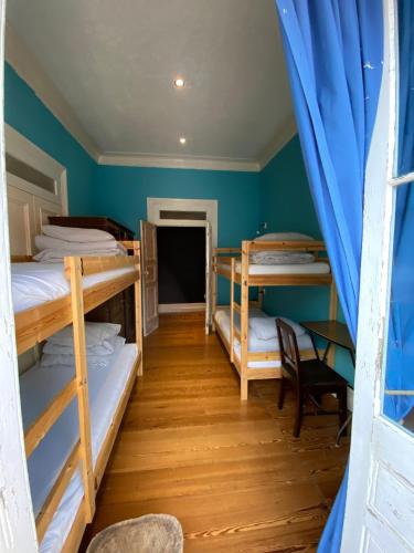 a room with four bunk beds and a table at The Pink House in Faja Grande