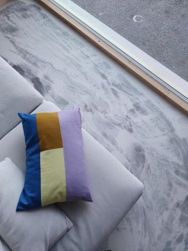 a colorful pillow sitting on top of some pillows at Huoneisto Sipoossa in Helsinki