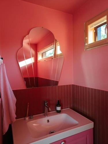 a red bathroom with a sink and a mirror at Huoneisto Sipoossa in Helsinki