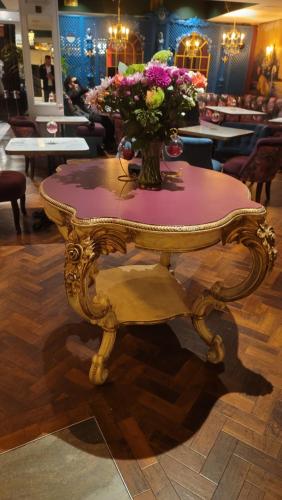 a table with a vase of flowers on top of it at Bingham Townhouse Hotel in Bingham