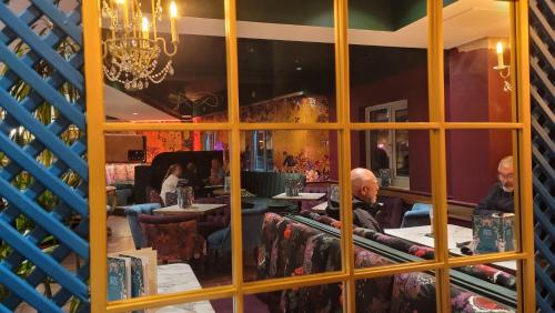 a reflection of two men sitting at a table in a restaurant at Bingham Townhouse Hotel in Bingham