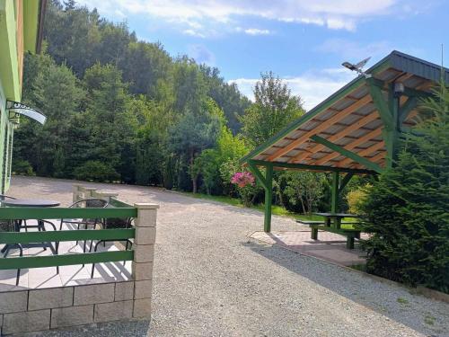 a picnic shelter with two benches in a park at W zieleni in Polanica-Zdrój