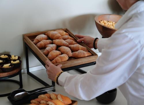 a woman holding a tray of pastries on a table at Kabadoni Boutique Hotel in Sighnaghi