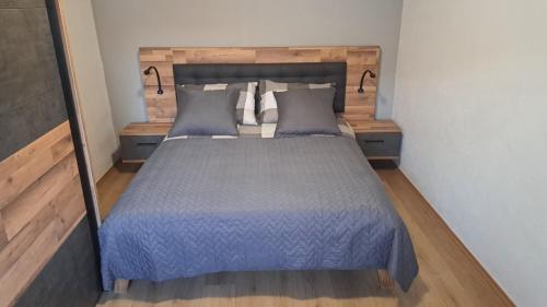 a bedroom with a bed with blue sheets and pillows at Stone House Josipa in Ražanj
