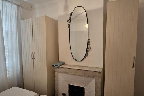 une salle de bain avec un miroir au-dessus d'une cheminée dans l'établissement Sérénité, à Marseille