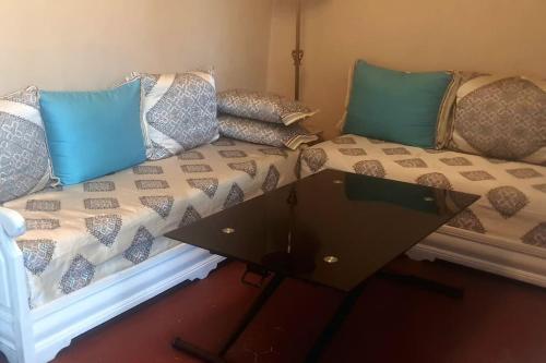 - une table basse devant un canapé avec des oreillers dans l'établissement Sérénité, à Marseille