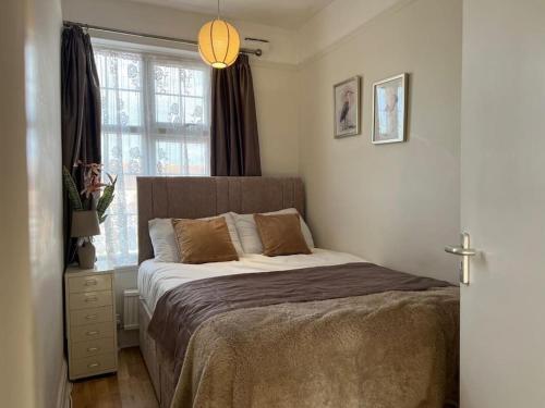 a bedroom with a bed and a window at Home in London, N14 nearby Trent Park and Alexandra Palace in East Barnet