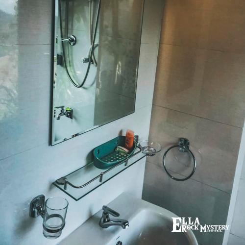 a bathroom with a sink with a mirror and a shower at Ella Rock Mystery Guest in Ella