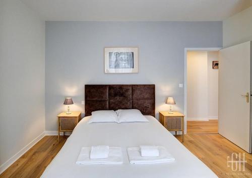 une chambre avec un grand lit blanc avec deux lampes dans l'établissement Begonia - Place Plumereau, à Tours